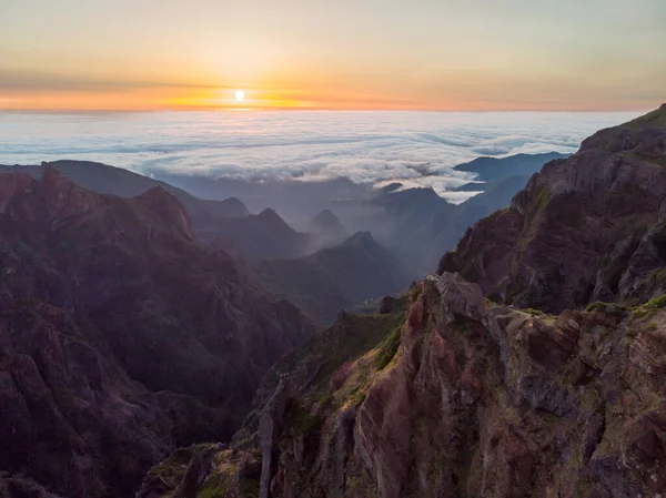 Захватывающий пейзаж восхода солнца над морем облаков в окружении вулканических гор. — стоковое фото