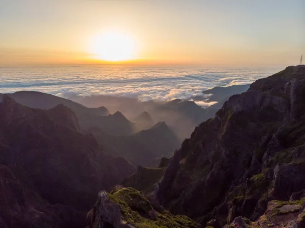 Spektakulärt landskap utsikt över soluppgången stiger över havet av moln omgiven av vulkaniska berg. — Stockfoto