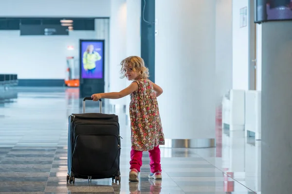 Cute blondynka dziewczyna z bagażu podróżnych na lotnisku. — Zdjęcie stockowe