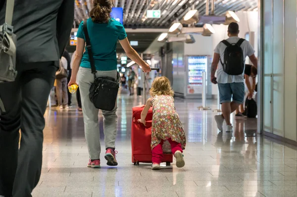 Widok z tyłu matki i córki z bagażem podróżnym złapany samolot. — Zdjęcie stockowe