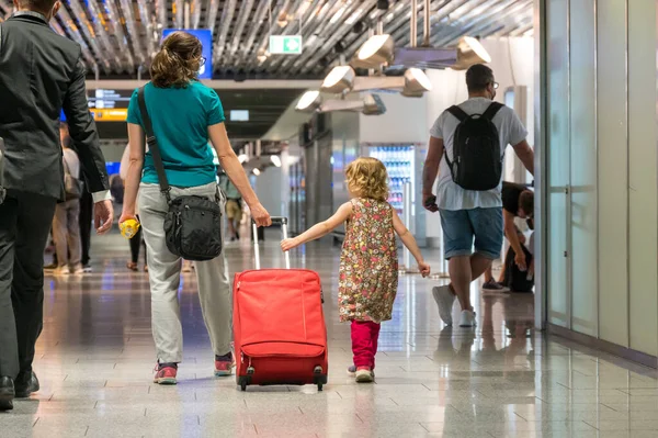 Widok z tyłu matki i córki z bagażem podróżnym złapany samolot. — Zdjęcie stockowe