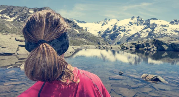 Mujer joven mirando el lago de la montaña — Zdjęcie stockowe