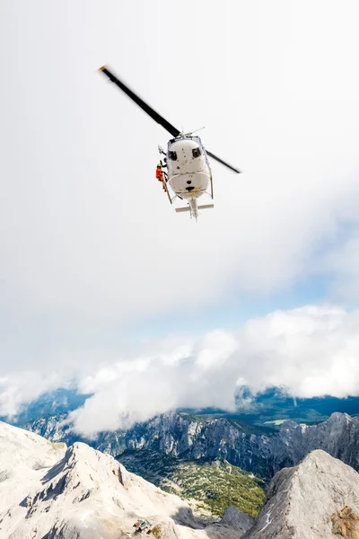 Helicopter with a rescuer standing on its ledge — Stock Photo, Image