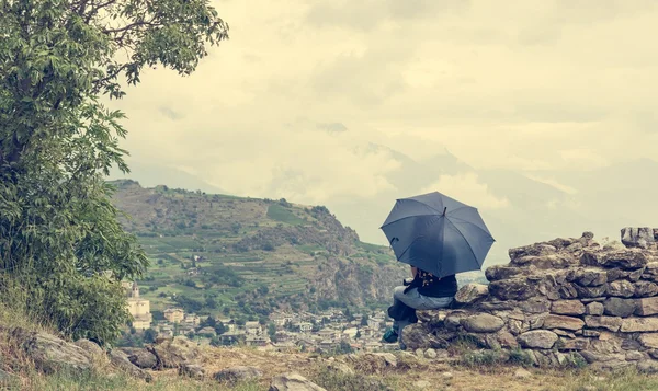 Sentado menina segurando um guarda-chuva — Fotografia de Stock