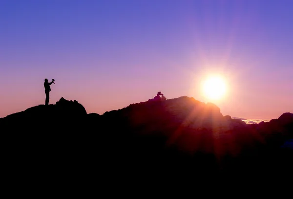 Silhueta de uma pessoa fotografando o nascer do sol — Fotografia de Stock