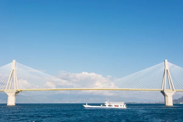 Поромний човен, що пливе під підвісним мостом — стокове фото