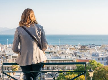 Bir şehir üzerinde bir bankta oturan kız