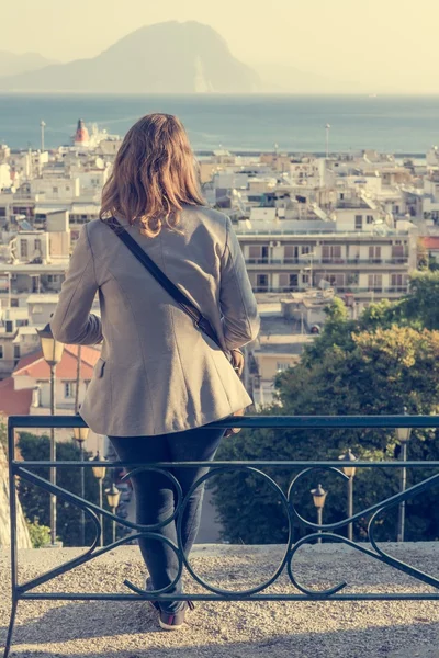 Geschäftsfrau sitzt auf einer Bank über einer Stadt — Stockfoto