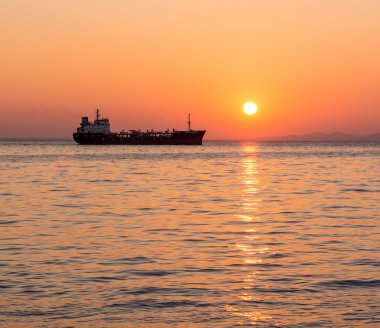 Günbatımı ile kargo gemisi denizde