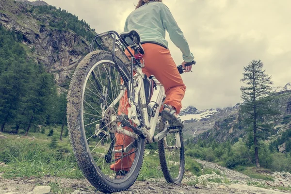 Mujer de pie en su bicicleta — Foto de Stock