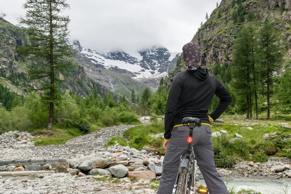 Ciclista posando en un valle de montaña — Foto de Stock