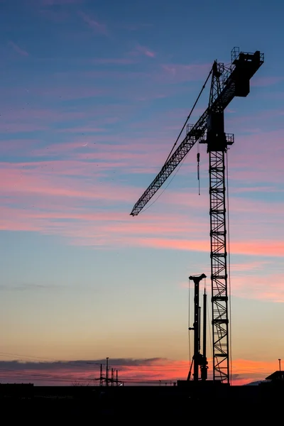 Bouw kraan bij zonsondergang. — Stockfoto