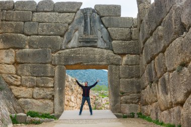 Tourist posing under famous Lion gate entrance. clipart