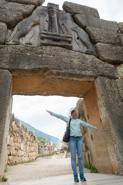 Turista posando bajo la famosa puerta del León . — Foto de Stock