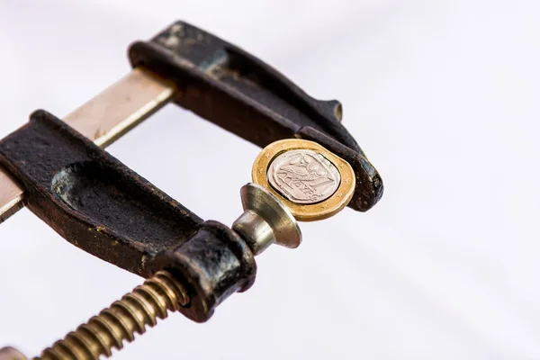 Greek Euro coin squezzed in clamp. — Stock Photo, Image