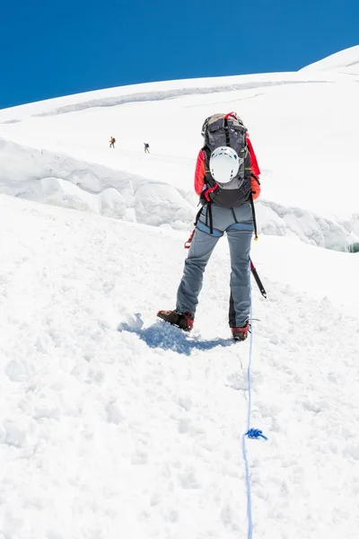 Kvinnlig bergsbestigare stigande en glaciär. — Stockfoto