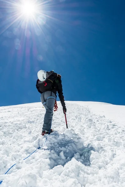 Female climber ascending a snowy slope. — Stock Photo, Image