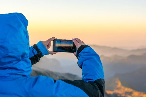 Žena horské fotografie s její telefon. — Stock fotografie