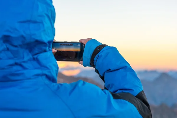 Femme prenant une photo de montagne avec son téléphone . — Photo