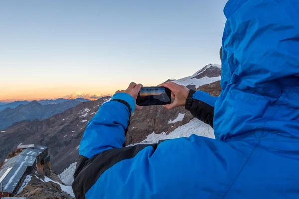 Kvinnan tar ett berg foto med sin telefon. — Stockfoto