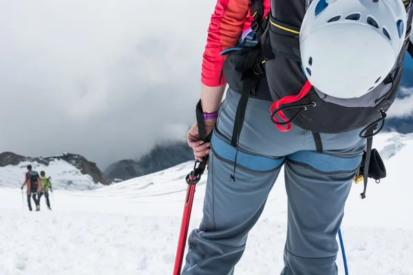 Alpinist op zoek naar beneden de helling. — Stockfoto