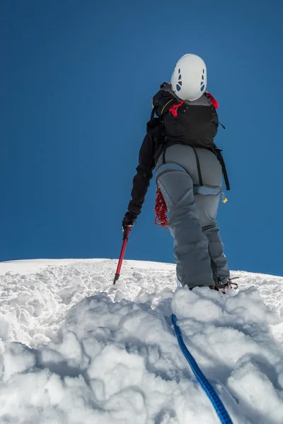 Female climber ascending a snowy slope. — Stock Photo, Image