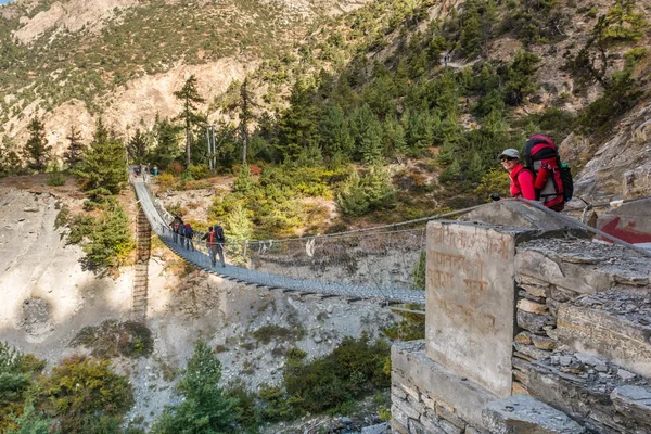 Mladý trekker chystalo přes visutý most. — Stock fotografie