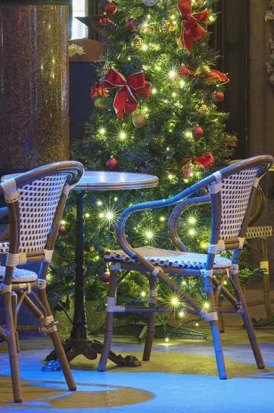 Light decorated Christmas tree with empty rattan chairs — Stock Photo, Image