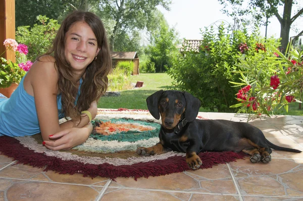 Giovane donna e un giovane cane bassotto Fotografia Stock