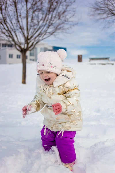 穿着白色夹克的小女孩玩得很开心 在外面玩耍 周围都是雪 冬季健康儿童活动概念 — 图库照片