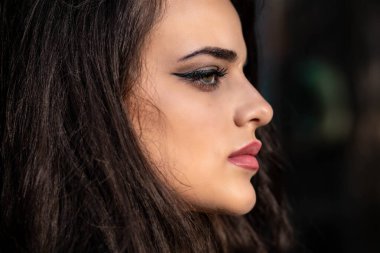 Güzel esmer bir kızın ela gözlü portresi. Yan görünüm