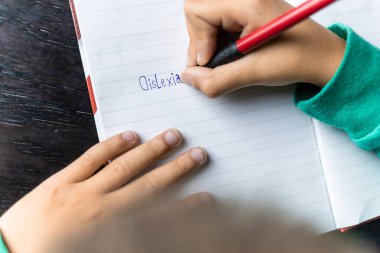 Defterine okuma güçlüğü çeken bir çocuk, yazım hatası. Öğrenme bozukluğu