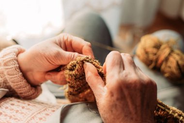 Yaşlı kadın ellerinin örgü ördüğü yakın çekim. Kış Zamanı