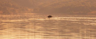 Sabah gölde bir balıkçı teknesi. Pankart, geniş biçim
