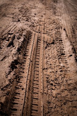 Çamurlu yolda araba lastiği izi var. Boşluğu kopyala