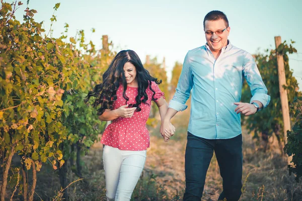 若いロマンチックなカップルがブドウ畑を駆け抜ける — ストック写真