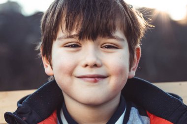 Kâküllü, gülümseyen küçük bir çocuğun portresi.