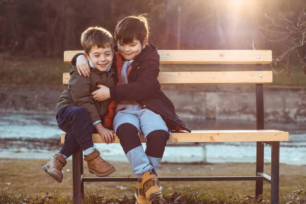 Dos Chicos Lindos Hermanos Sentados Banco Siendo Cariñosos Uno Con — Foto de Stock