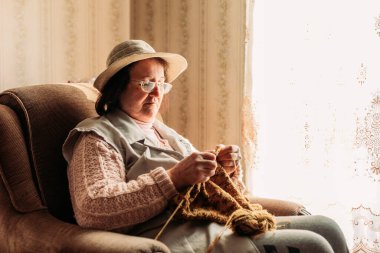 Torunları için kazak ören yaşlı bir kadın.