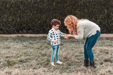 Annesi parkta oğluyla oynuyor.