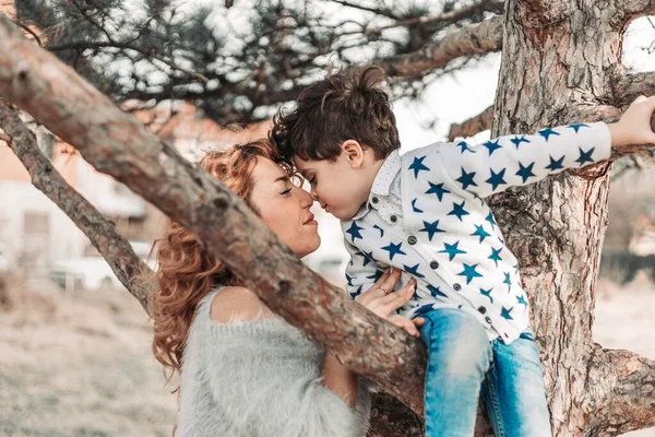 母親と息子のエスキモーは木の上に座ってキスをする 愛と愛情 — ストック写真