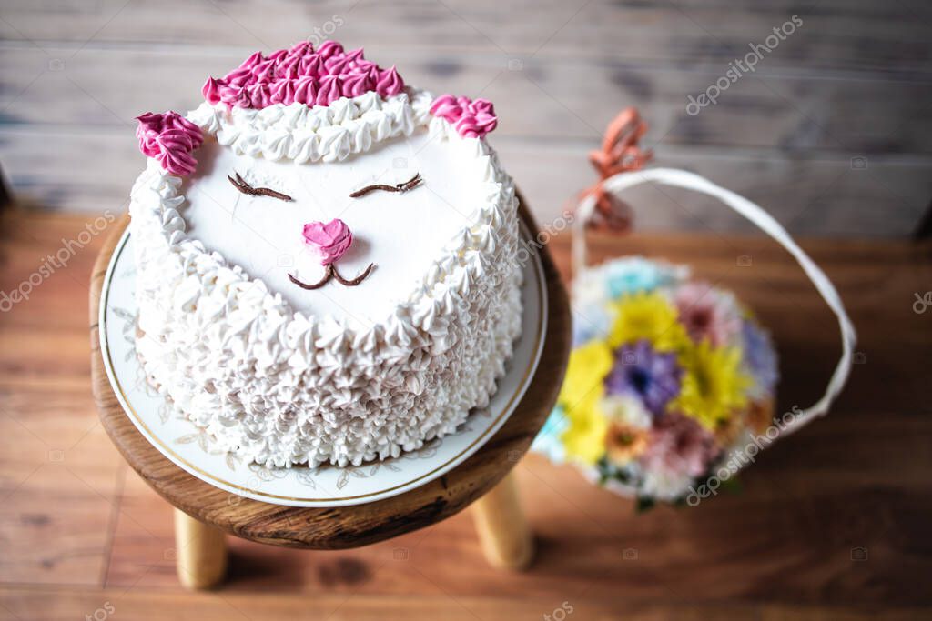 Top view of white, cream cake with cat decoration
