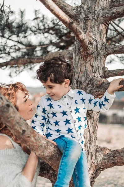 母は木の上に座っている間に 彼女の幼児の息子を抱いている 愛と愛情 — ストック写真