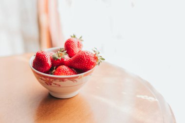 Masadaki seramik haykırışta taze çilekler. Sabah keyfi zamanı.