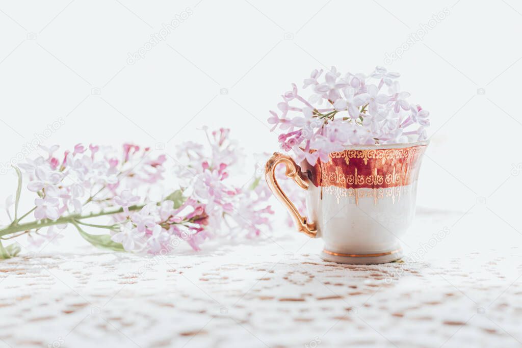 Retro tea cup with lilac flowers in it. Home decoration. Springtime vibes
