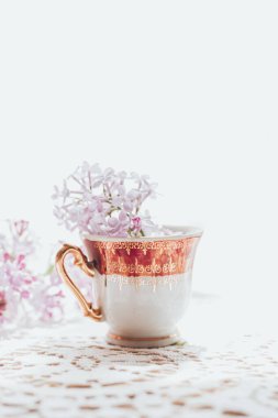 İçinde leylak çiçekleri olan Retro çay bardağı. Ev dekorasyonu. İlkbahar titreşimleri
