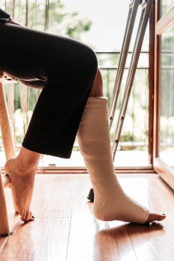 Sandalyede oturan kırık bilekli bir kadının yakın çekimi.