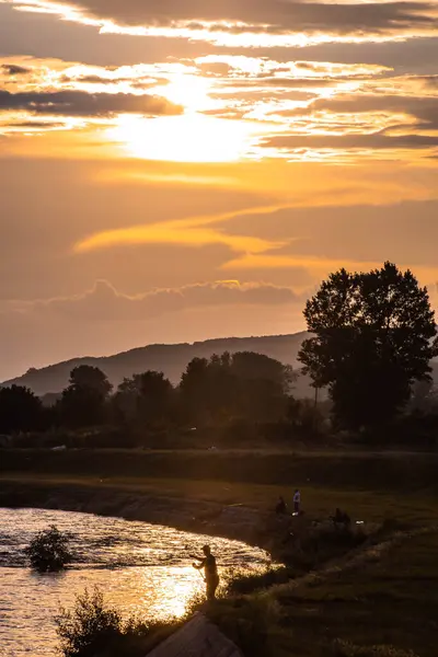 Puesta Sol Sobre Río Con Siluetas Pescador Orilla Del Río —  Fotos de Stock