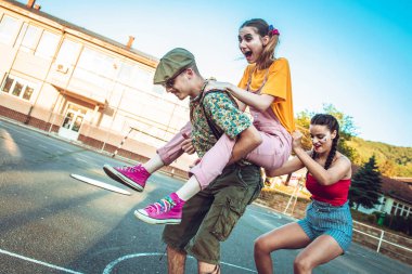 Bir grup arkadaş dışarıda takılıyor. Bir kız arkadaşına biniyor, diğeri de arabanın arkasında. Pozitif titreşimler