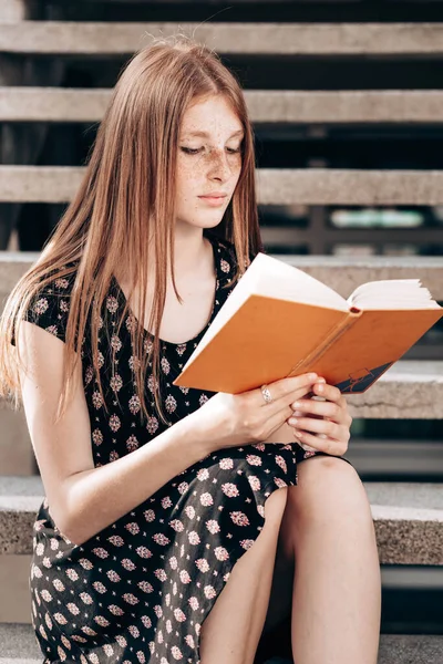 Młoda Ruda Nastolatka Siedząca Schodach Przed Szkołą Czytająca Książkę — Zdjęcie stockowe